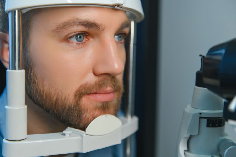 Adult man eyesight test with binocular slit-lamp. Checking retina of a male eye close-up. Ophthalmology Clinic